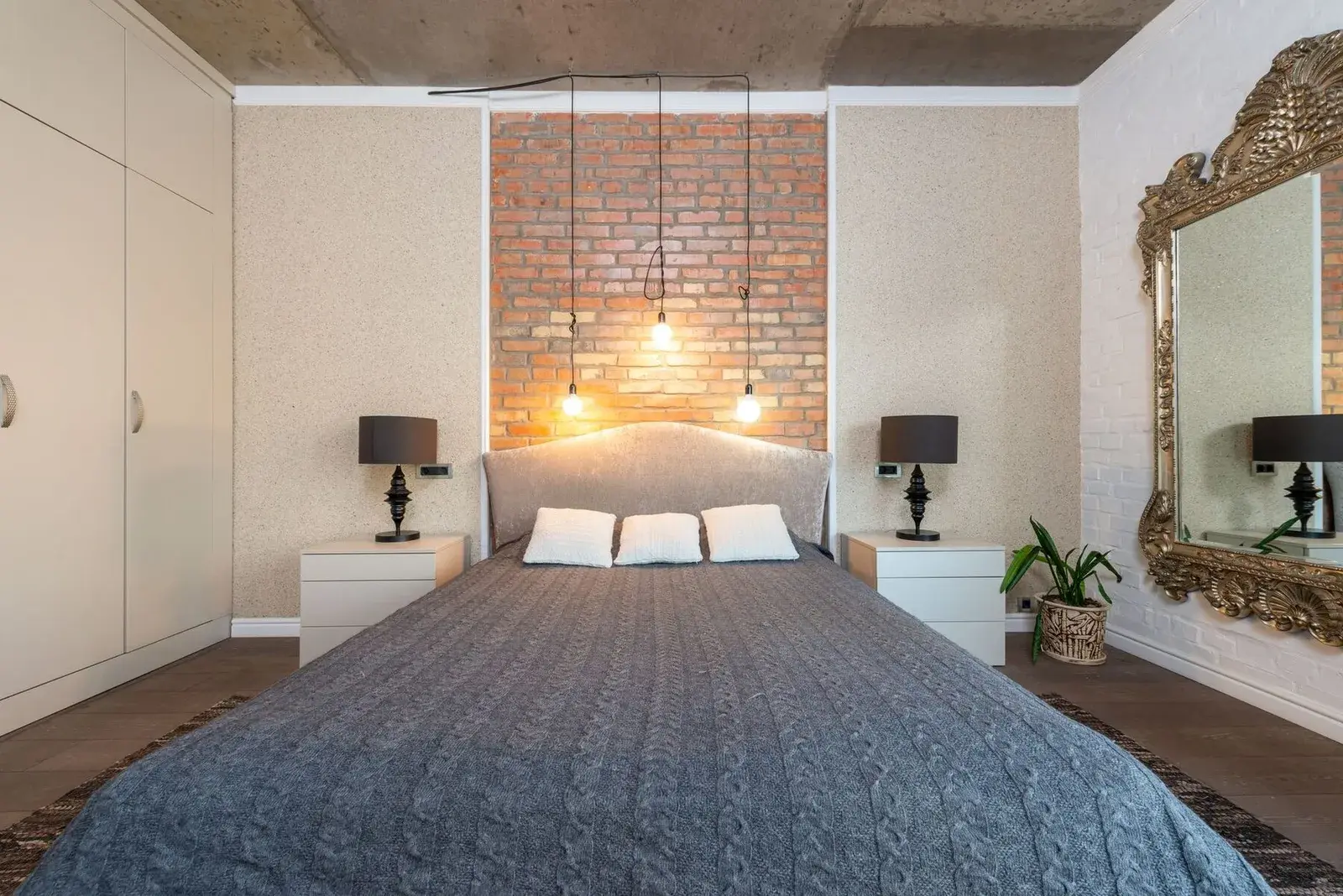 Chambre avec mur de brique et suspensions